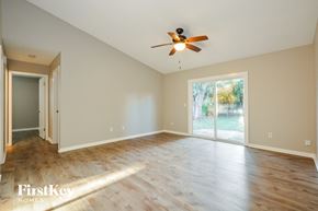 Edgewater house for rent - an empty living room with wood floors and a ceiling fan