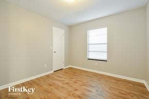 Edgewater house for rent - a bedroom with a wood floor and white walls and a window