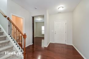 Durham house for rent - A hallway with a wooden staircase and a white door.