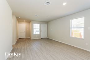 Converse house for rent - A spacious empty room with light wood flooring and white walls.