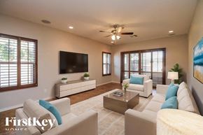 Mesa house for rent - A living room with a white couch, a coffee table, and a flat screen TV.