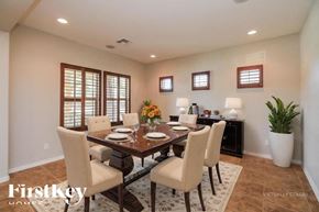 Mesa house for rent - A dining room with a table set for six and a vase of flowers on the table.