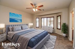 Mesa house for rent - A bedroom with a large bed and a ceiling fan.