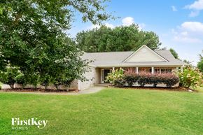 Loganville house for rent - a white brick house with a lawn and trees