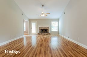 Loganville house for rent - an empty living room with wood floors and a fireplace