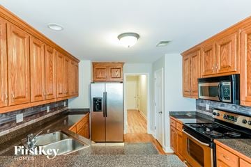 Loganville house for rent - a kitchen with wooden cabinets and stainless steel appliances
