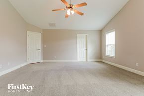 Loganville house for rent - the master bedroom has a carpeted floor and a ceiling fan