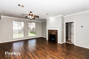 Seabrook house for rent - an empty living room with a fireplace and a ceiling fan