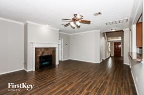 Seabrook house for rent - a living room with a fireplace and a ceiling fan