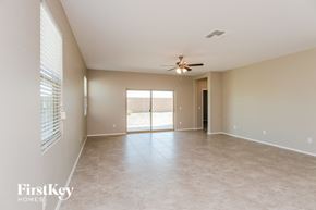 San Tan Valley house for rent - an empty living room with a ceiling fan and a window