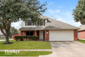 Houston house for rent - a home with a large tree in the front yard and a driveway