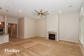 Humble house for rent - a living room with a fireplace and a ceiling fan