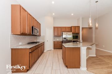 Humble house for rent - a kitchen with wooden cabinets and stainless steel appliances