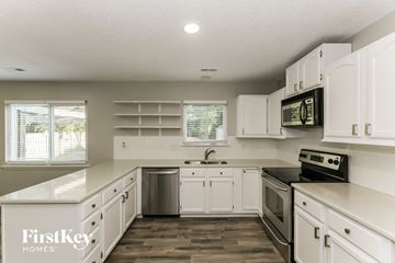 Charlotte house for rent - A kitchen with white cabinets and a wooden floor.