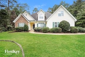 Fayetteville house for rent - A house with a lawn and trees in the background.