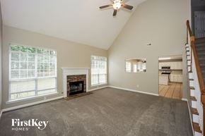 Fayetteville house for rent - A spacious living room with a fireplace and a staircase.