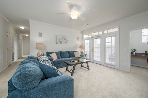 Columbus apartment for rent - A living room with a blue couch and a ceiling fan.