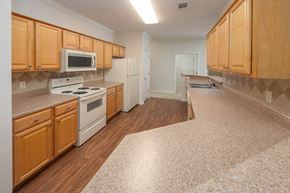 Columbus apartment for rent - A kitchen with wooden cabinets and a white stove top oven.