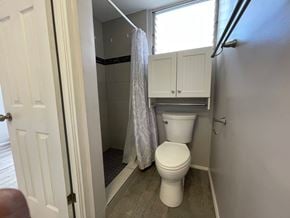Honolulu apartment for rent - A small bathroom with a toilet and a shower.