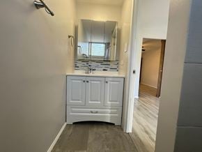 Honolulu apartment for rent - A bathroom with a white cabinet and a mirror above it.