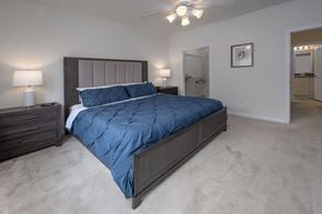 Columbus apartment for rent - A bedroom with a large bed and a ceiling fan.