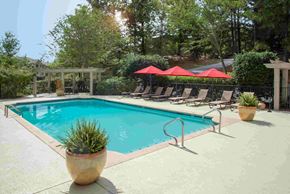 Columbus apartment for rent - A pool with a red umbrella and a potted plant.