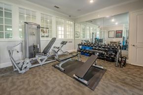 Columbus apartment for rent - A home gym with a variety of equipment including a treadmill, weights, and a bench press.