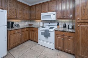 Columbus apartment for rent - A kitchen with wooden cabinets and a white stove top oven.