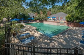 Columbus apartment for rent - A pool surrounded by trees and a fence.