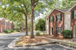 Columbus apartment for rent - A tree in front of a building with a red brick wall.