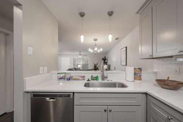 Columbus apartment for rent - A modern kitchen with a stainless steel dishwasher and white countertops.