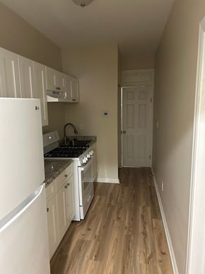 Washington apartment for rent - A kitchen with white cabinets and a white refrigerator.