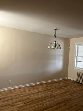 Washington apartment for rent - A room with wooden floors and a chandelier.