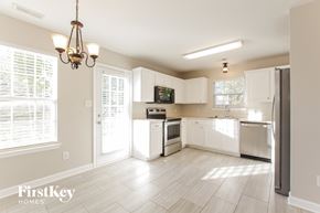 Waxhaw house for rent - A kitchen with white appliances and cabinets is shown.