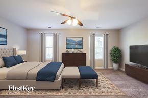 Waxhaw house for rent - A bedroom with a large bed and a flat screen TV.