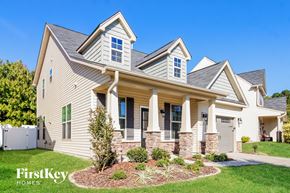 Winston-Salem house for rent - a house with tan siding and stone pillars and a lawn