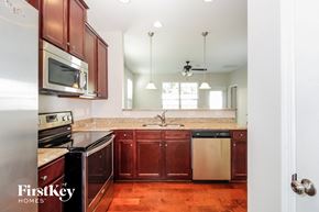 Winston-Salem house for rent - a kitchen with wooden cabinets and stainless steel appliances and granite counter tops