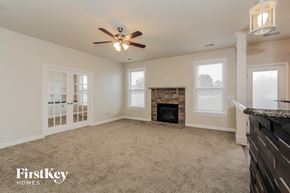 Mooresville house for rent - a living room with a fireplace and a ceiling fan