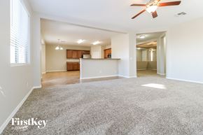 Buckeye house for rent - A spacious living room with a ceiling fan and a carpeted floor.