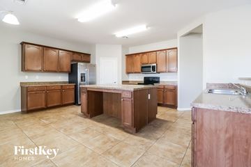 Buckeye house for rent - A kitchen with brown cabinets and a tile floor.