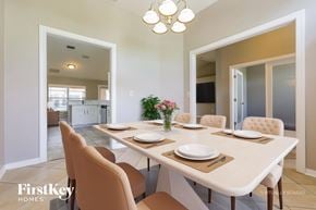 North Port house for rent - A dining room with a table set for two and a chandelier hanging from the ceiling.