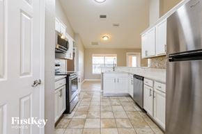 North Port house for rent - A kitchen with a stainless steel refrigerator and white cabinets.