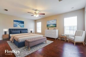 North Port house for rent - A bedroom with a bed, dresser, and chair.
