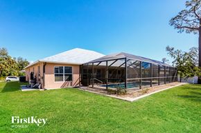 North Port house for rent - A house with a pool and a covered patio area.
