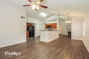Glendale house for rent - A spacious living room with a ceiling fan and wooden flooring.