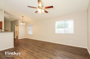 Glendale house for rent - A spacious room with a ceiling fan and wooden flooring.