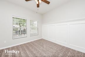 Saint Cloud house for rent - a bedroom with white walls and carpet and a ceiling fan