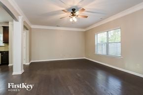 Woodstock house for rent - an empty living room with wood floors and a ceiling fan