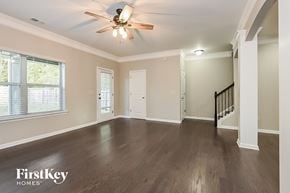 Woodstock house for rent - an empty living room with wood floors and a ceiling fan