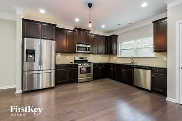 Woodstock house for rent - a kitchen with dark wood cabinets and stainless steel appliances
